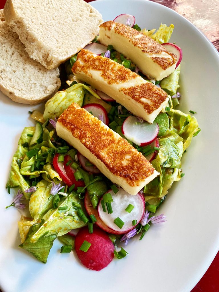 Teller mit buntem Salat, Grilläsestreifen, 2 Scheiben Baguette