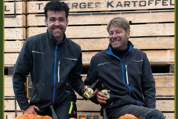 Zwei Männer mit Kartoffeln und Hierflaschen in der Hand